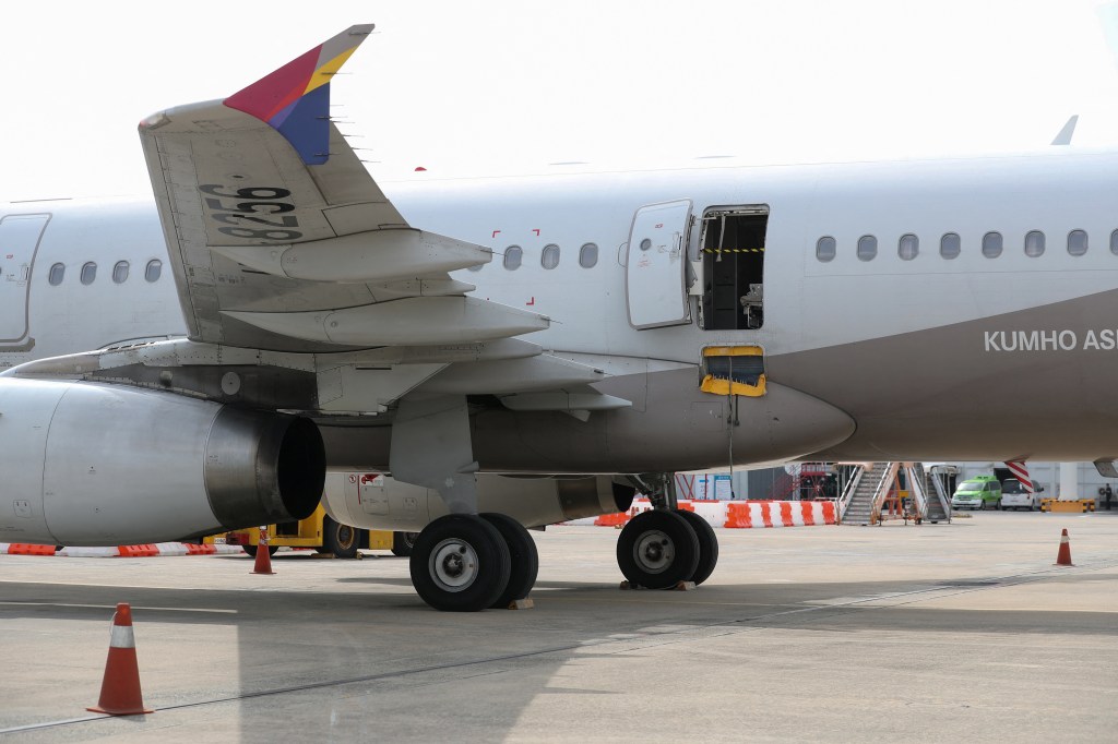 An opened door of an Asiana Airlines plane is seen at Daegu International Airport in Daegu on May 26, 2023, after it was manually opened by a passenger just 200 metres above the ground before landing causing some to have breathing difficulty but with no major injuries. (Photo by YONHAP / AFP) / - South Korea OUT / REPUBLIC OF KOREA OUT NO ARCHIVES RESTRICTED TO SUBSCRIPTION USE