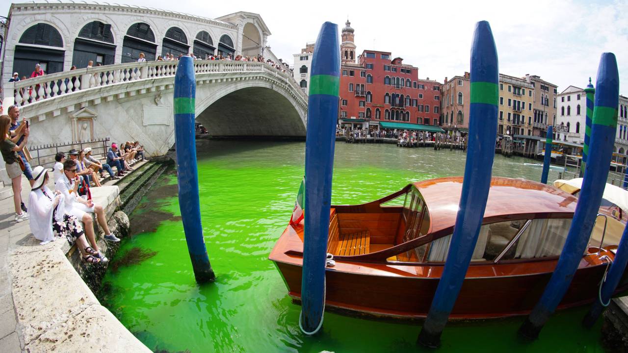 A photo taken and made available on May 28, 2023 by Italian news agency Ansa, shows fluorescent green waters below the Rialto Bridge in Venice's Grand Canal. The prefect called an urgent meeting on May 28 with the police to investigate the origin of the liquid, as gondoliers were getting lost in conjectures about the color's origin. (Photo by STRINGER / ANSA / AFP) / Italy OUT