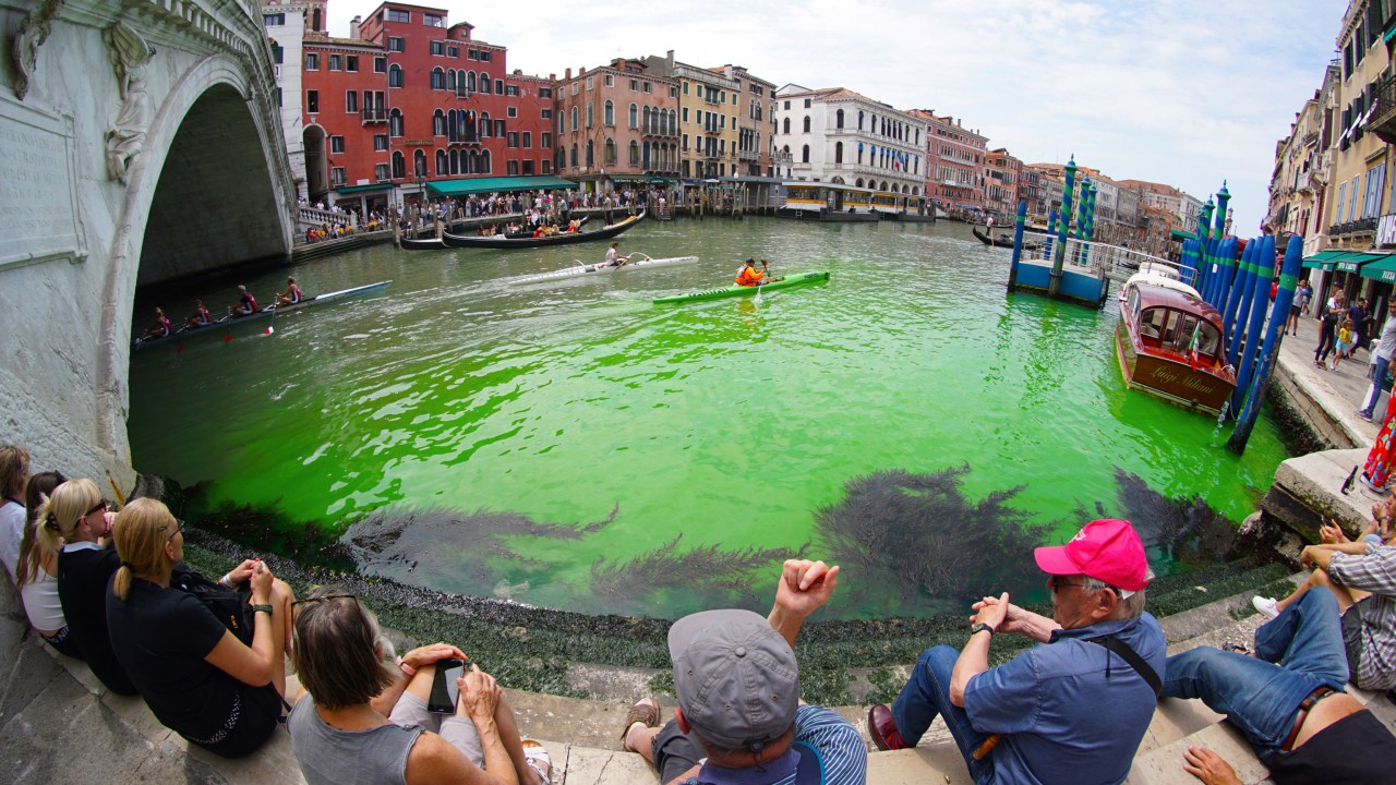 TOPSHOT - A photo taken and made available on May 28, 2023 by Italian news agency Ansa, shows fluorescent green waters below the Rialto Bridge in Venice's Grand Canal. The prefect called an urgent meeting on May 28 with the police to investigate the origin of the liquid, as gondoliers were getting lost in conjectures about the color's origin. (Photo by STRINGER / ANSA / AFP) / Italy OUT