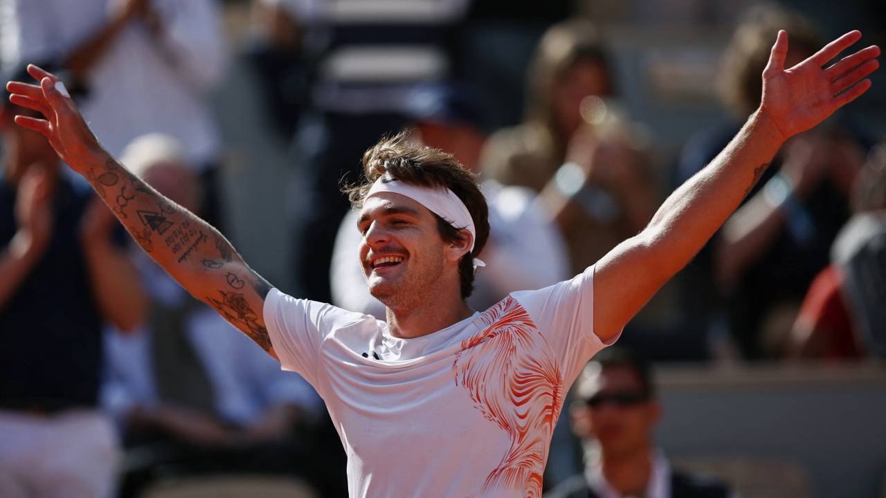 Brazil's Thiago Seyboth Wild celebrates after winning against Russia's Daniil Medvedev during their men's singles match on day three of the Roland-Garros Open tennis tournament at the Court Philippe-Chatrier in Paris on May 30, 2023. (Photo by Anne-Christine POUJOULAT / AFP)