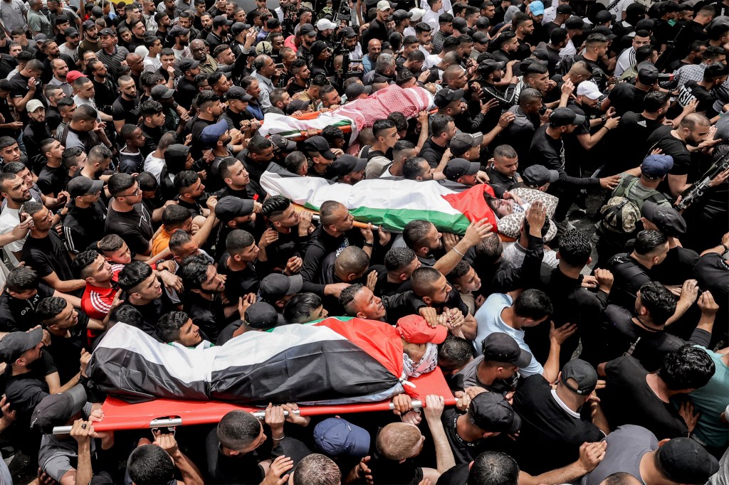 EDITORS NOTE: Graphic content / Mourners march with the bodies of Palestinian fighters killed overnight in the Balata camp for Palestinian refugees on the outskirts of Nablus in the occupied West Bank on May 22, 2023. Israeli forces killed three fighters overnight on May 222 in what the army described as an operation to capture terrorist suspects. In a statement, the Palestinian health ministry identified the three men killed in Balata camp in Nablus as Muhammad Abu Zaytoun, 32, Fathi Abu Rizk, 30, and Abdullah Abu Hamdan, 24. (Photo by Zain JAAFAR / AFP)