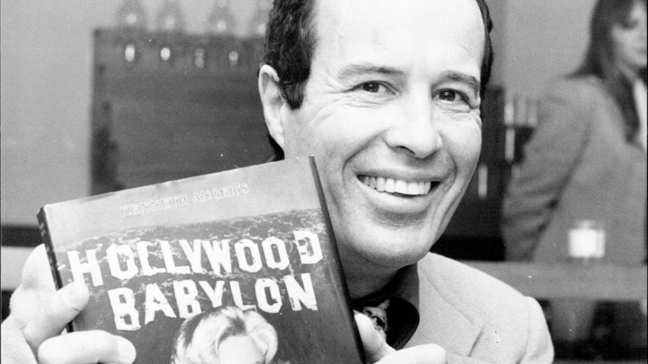 Kenneth Anger segura seu livro, 'Hollywood Babylon'