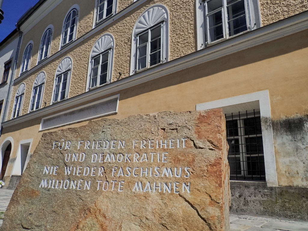 BRAUNAU AM INN, AUSTRIA - 2017/08/30: In front of Hitlers birthplace there is a stone from a stone-quarry in Mauthausen concentration camp where prisoners had to work. "For peace, freedom and democracy. Never more fascism. Millions of dead warn." is written on it.In a simple yellow house in Salzburger Vorstadt 15, Braunau am Inn, where his parents rented a small flat, Adolf Hitler was born on April 20th 1889. He later became the worst criminal in the history. In his birthplace in the Austrian town Braunau am Inn they try to forget him. They want to avoid the neo-nazi to make a pilgrimage site from this place. That´s why the state expropriated the building from the owner, Gerlinde Pommer - Angloher, last year, and plan to rebuild it and use it for charitative purposes. (Photo by Jana Cavojska/SOPA Images/LightRocket via Getty Images)