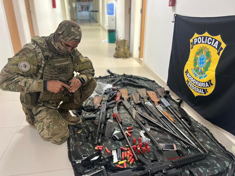 Policial rodoviário federal com armas apreendidas em operação na Terra Indígena Yanomami