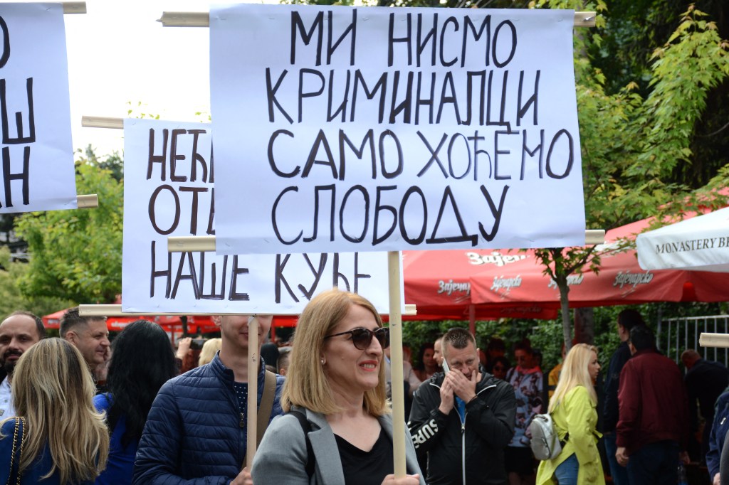A woman holds a banner, We are not criminals, we just want freedom, outside the Zvecan town hall in northern Kosovo on June 2, 2023, as tensions remained high after clashing with NATO-led peacekeepers (KFOR) earlier this week. Ethnic Serbs gathered again in a flashpoint town in north Kosovo on June 2, 2023 at the site of clashes earlier this week with NATO-led forces, as Pristina and Belgrade came under mounting international pressure to defuse tensions. (Photo by STRINGER / AFP)