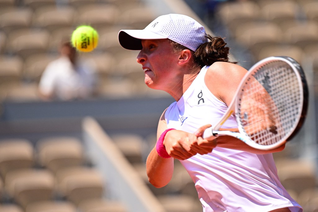 Poland's Iga Swiatek plays a backhand return to US Coco Gauff during their women's singles quarter final match on day eleven of the Roland-Garros Open tennis tournament at the Court Philippe-Chatrier in Paris on June 7, 2023. (Photo by Emmanuel DUNAND / AFP)