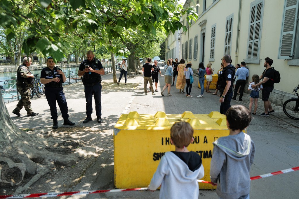 French police personnel maintain a secure cordon in Annecy, south-eastern France on June 8, 2023, following a mass stabbing in the French Alpine town. Seven people, including six children, have been injured in a mass stabbing in the town of Annecy in the French Alps, security sources told AFP. A man armed with a knife attacked a group of children aged around three years old as they played in a park near the lake in the town at around 9:45 am (0745 GMT), a security source who asked not to be named and a local official told AFP. (Photo by OLIVIER CHASSIGNOLE / AFP)