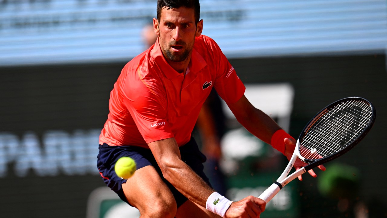 Serbia's Novak Djokovic plays a backhand return to Spain's Carlos Alcaraz Garfia during their men's singles semi-final match on day thirteen of the Roland-Garros Open tennis tournament at the Court Philippe-Chatrier in Paris on June 9, 2023. (Photo by Emmanuel DUNAND / AFP)