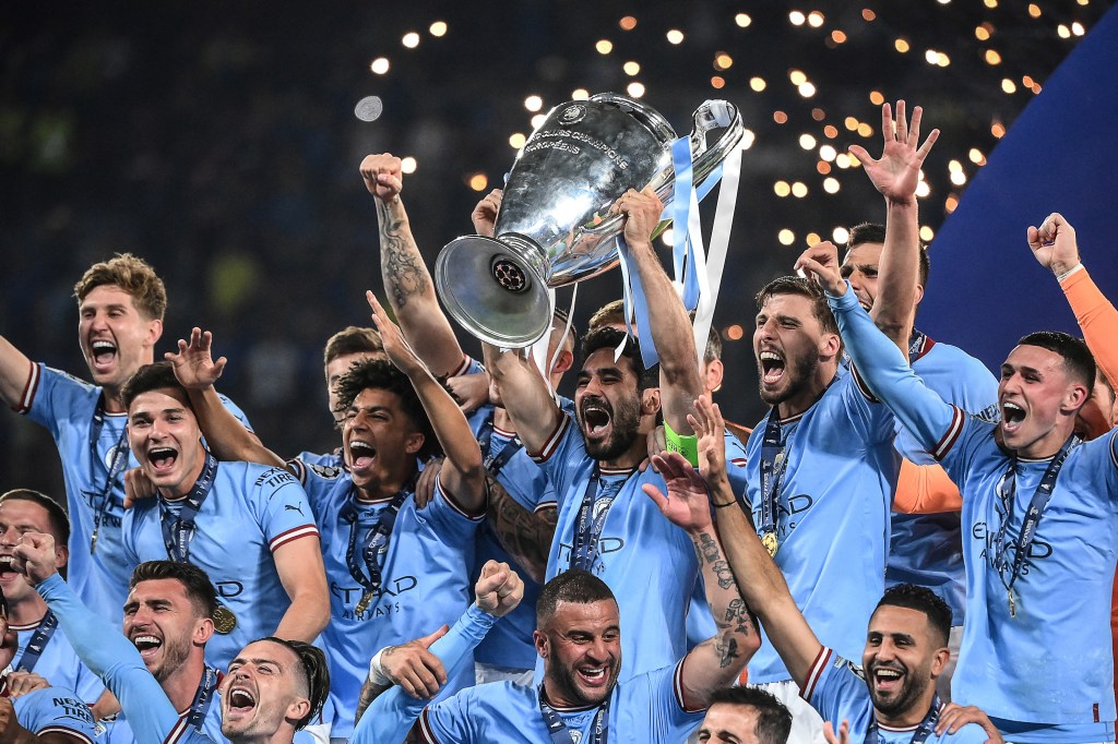 Manchester City's German midfielder #8 Ilkay Gundogan (C) lifts the European Cup trophy as they celebrate on the podium after winning the UEFA Champions League final football match between Inter Milan and Manchester City at the Ataturk Olympic Stadium in Istanbul, on June 10, 2023. (Photo by FRANCK FIFE / AFP)