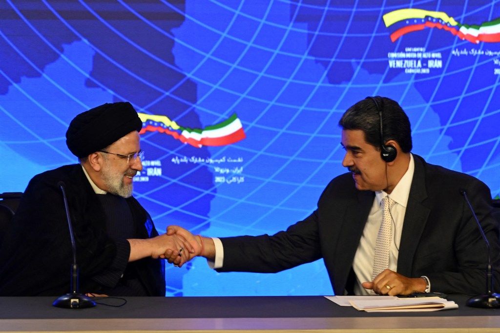 Iranian President Ebrahim Raisi (L) and Venezuelan President Nicolas Maduro shake hands during a joint press statement at Miraflores Presidential Palace in Caracas, on June 12, 2023. Iranian President Ebrahim Raisi arrived in Venezuela Monday for the start of a visit to "friendly countries" that also include Cuba and Nicaragua, all under sanctions from a common adversary, the United States. (Photo by YURI CORTEZ / AFP)