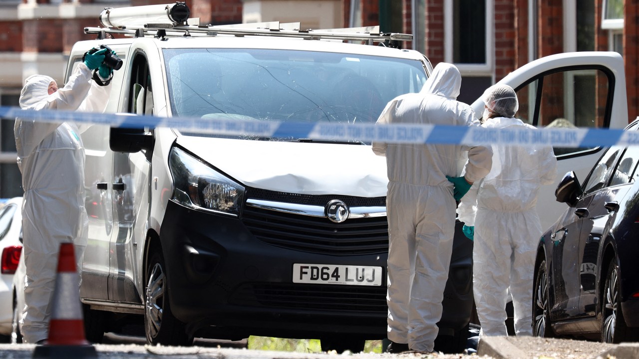 Police forensics officers work around a white van with a shattered windscreen, inside a police cordon on Bentinck Road in Nottingham, central England, following a 'major incident' in which three people were found dead. Police arrested a man Tuesday after three people were found dead and a van tried to mow down three others in the central English city of Nottingham in incidents authorities believe are linked. Nottingham's centre was cordoned off, with a heavy police presence, including some armed officers following the events that left residents shaken. (Photo by Darren Staples / AFP)