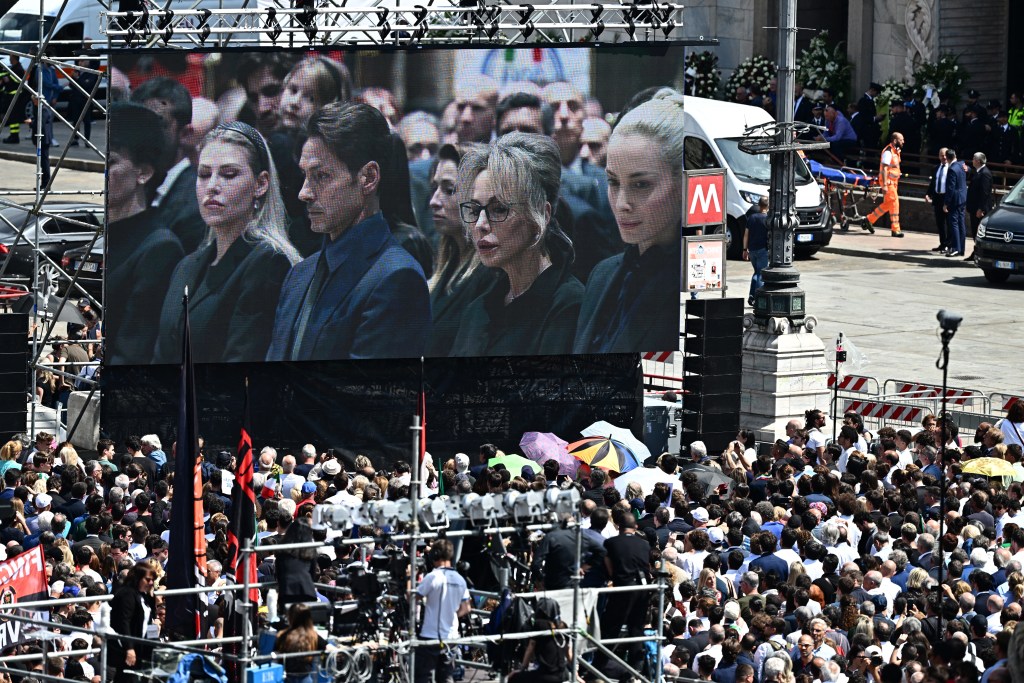 A view shows a screen displaying a live broadcast of Italian former Prime Minister, Silvio Berlusconi's daughter Barbara Berlusconi (L), son Pier Silvio Berlusconi, daughter Marina Berlusconi and partner of Silvio Berlusconi Marta Fascina inside the Duomo cathedral, at Piazza Duomo in Milan on June 14, 2023 for people to follow the state funeral for Italy's former prime minister and media mogul Silvio Berlusconi. (Photo by GABRIEL BOUYS / AFP)