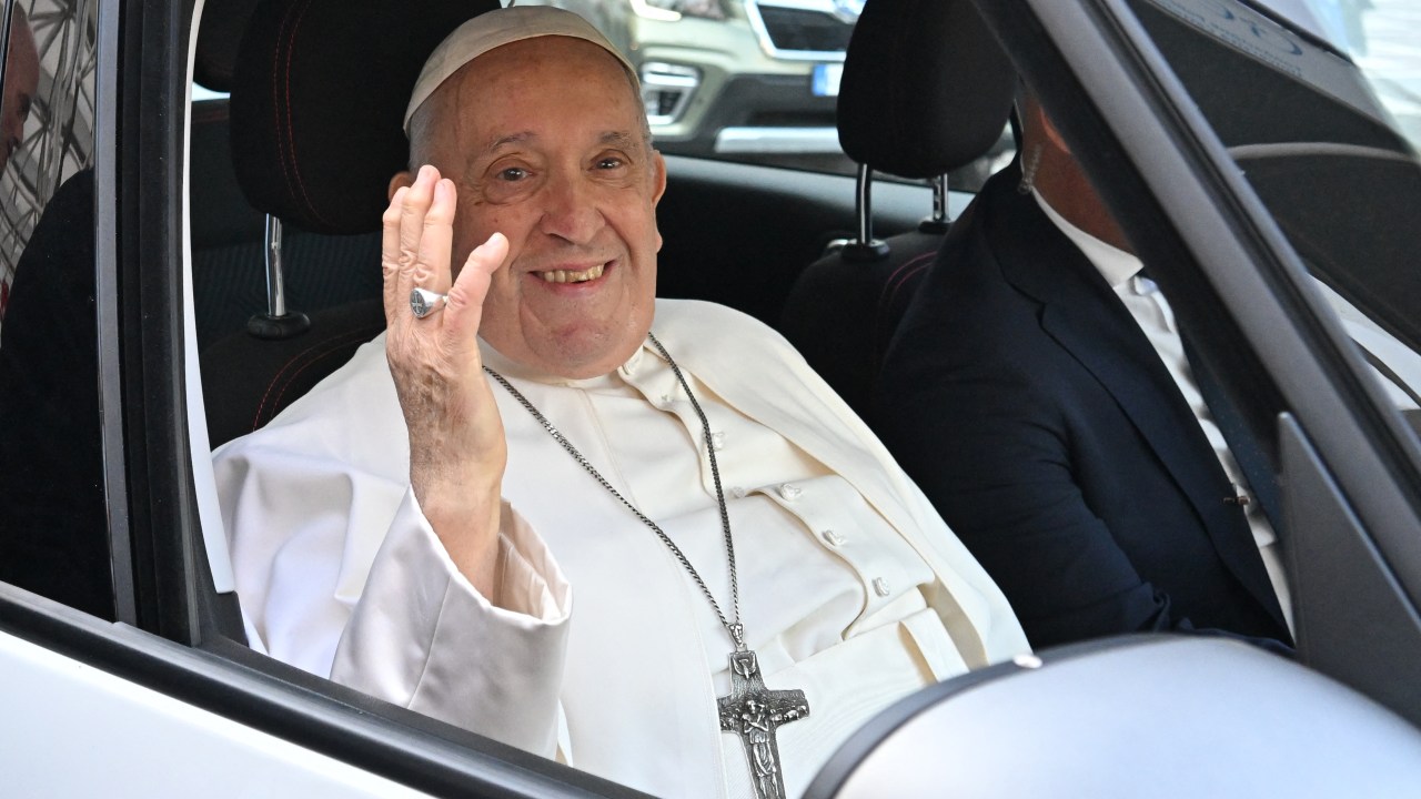 Pope Francis waves as he leaves after being discharged from the Gemelli hospital in Rome on June 16, 2023, where he underwent abdominal surgery last week. (Photo by Alberto PIZZOLI / AFP)