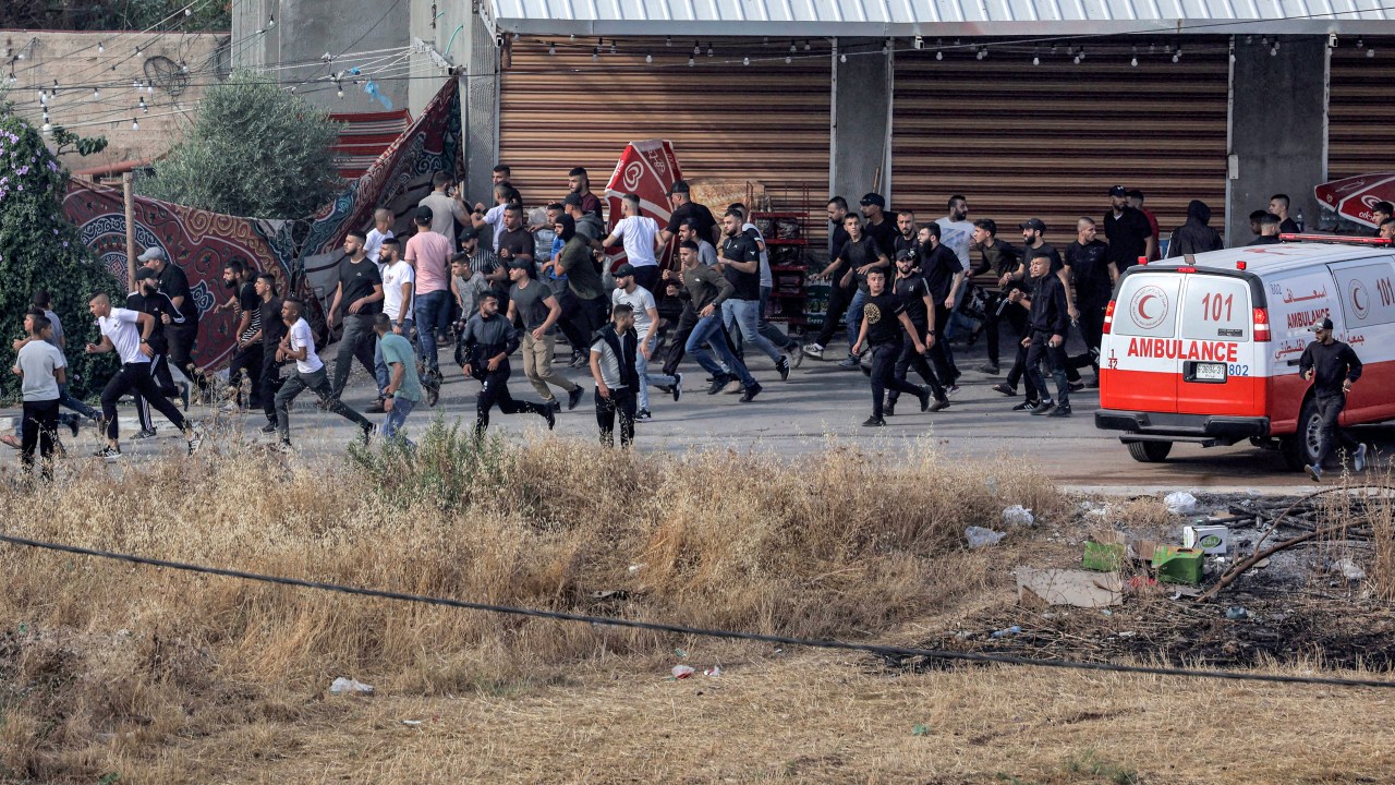 Palestinians flee during an Israeli army raid in Jenin in the occupied West Bank on June 19, 2023. Violent clashes erupted in Jenin on June 19 during an Israeli raid on the West Bank city in which the army fired missiles from a helicopter, according to an AFP photographer at the scene. (Photo by Jaafar ASHTIYEH / AFP)