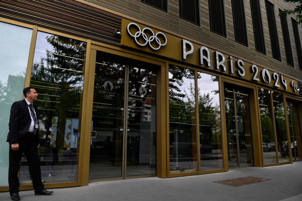 A security member stands at the entrance of the headquarters of the Paris 2024 Olympics (Cojo) headquarters as Police raided just over a year out from the opening ceremony of the quadrennial sporting showpiece, in Saint-Denis, northern Paris, on June 20, 2023. (Photo by JULIEN DE ROSA / AFP)