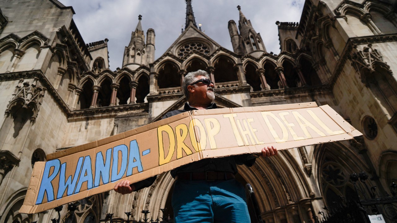 (FILES) A demonstrator holds a placard during a protest against Britain's Rwanda asylum plan outside the High Court in London on June 13, 2022. The Court of Appeal on June 29, 2023 ruled that the UK government's plan to send asylum seekers to Rwanda was unlawful as the African nation could not be considered a safe third country. Three judges said that "unless deficiencies" in Rwanda's asylum system were corrected, "removal of asylum seekers to Rwanda will be unlawful." (Photo by Niklas HALLE'N / AFP)