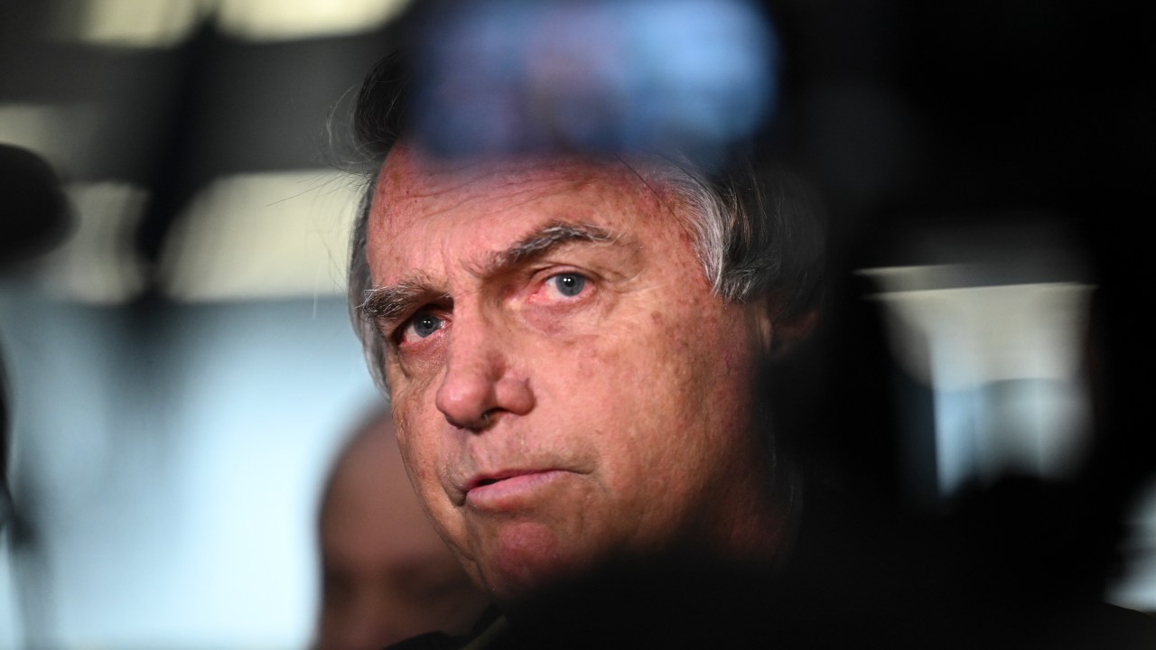 Former Brazilian President Jair Bolsonaro speaks to members of the media upon arrival at the Santos Dumont Airport in Rio de Janeiro, Brazil, on June 29, 2023. Judges will continue delivering verdicts Thursday on charges that far-right ex-president Jair Bolsonaro broke the law with his unproven allegations against Brazil's election system, which could see him banned from holding office for eight years. (Photo by MAURO PIMENTEL / AFP)
