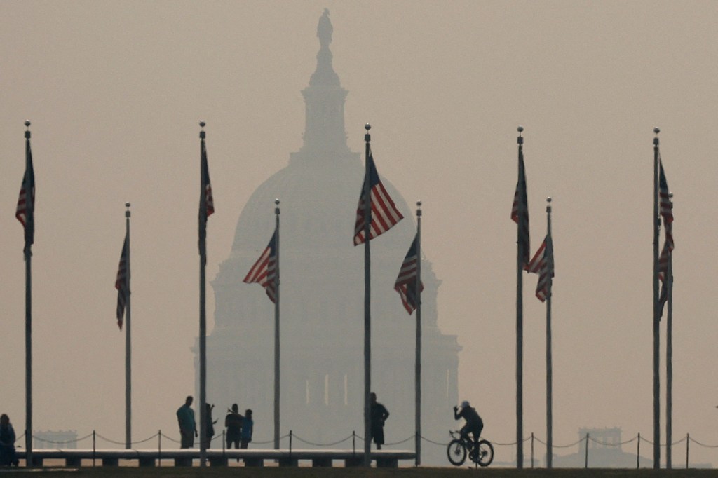 WASHINGTON, DC - JUNE 07: Tourists walk around the base of the Washington Monument as wildfire smoke casts a haze of the U.S. Capitol on the National Mall on June 07, 2023 in Washington, DC. Air pollution alerts were issued across the United States due to smoke from wildfires that have been burning in Canada for weeks. Chip Somodevilla/Getty Images/AFP (Photo by CHIP SOMODEVILLA / GETTY IMAGES NORTH AMERICA / Getty Images via AFP)