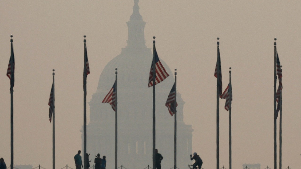 WASHINGTON, DC - JUNE 07: Tourists walk around the base of the Washington Monument as wildfire smoke casts a haze of the U.S. Capitol on the National Mall on June 07, 2023 in Washington, DC. Air pollution alerts were issued across the United States due to smoke from wildfires that have been burning in Canada for weeks. Chip Somodevilla/Getty Images/AFP (Photo by CHIP SOMODEVILLA / GETTY IMAGES NORTH AMERICA / Getty Images via AFP)