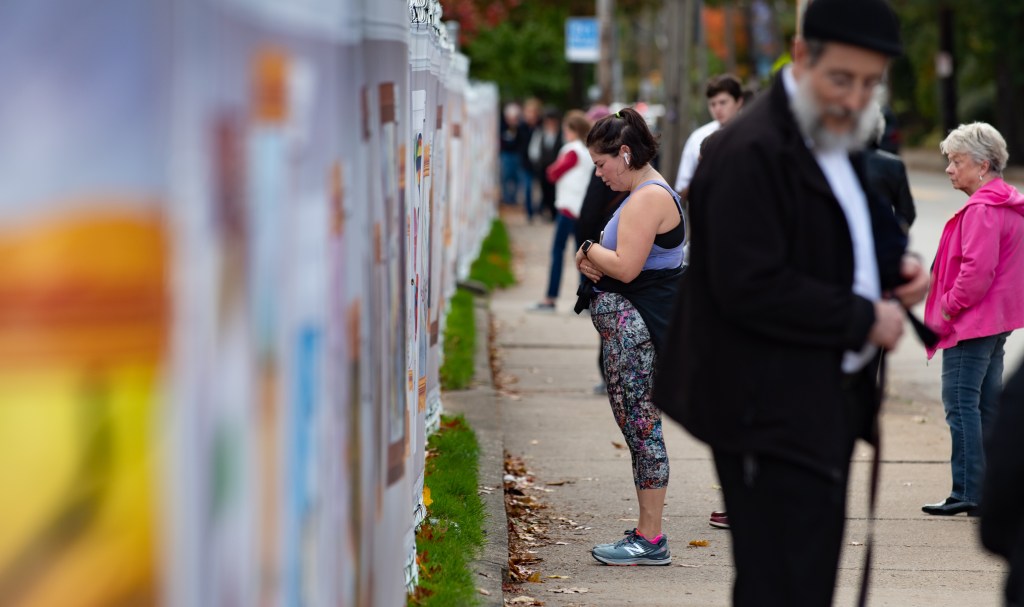 PITTSBURGH, PA - OCTOBER 27: Visitors look at inspired artworks along the fence at the Tree of Life Synagogue on the 1st Anniversary of the attack on October 27, 2019 in Pittsburgh, Pennsylvania. One year ago, Robert Bowers killed 11 people and wounded severa others during an attack of the Tree of Life synagogue. (Photo by Jeff Swensen/Getty Images)