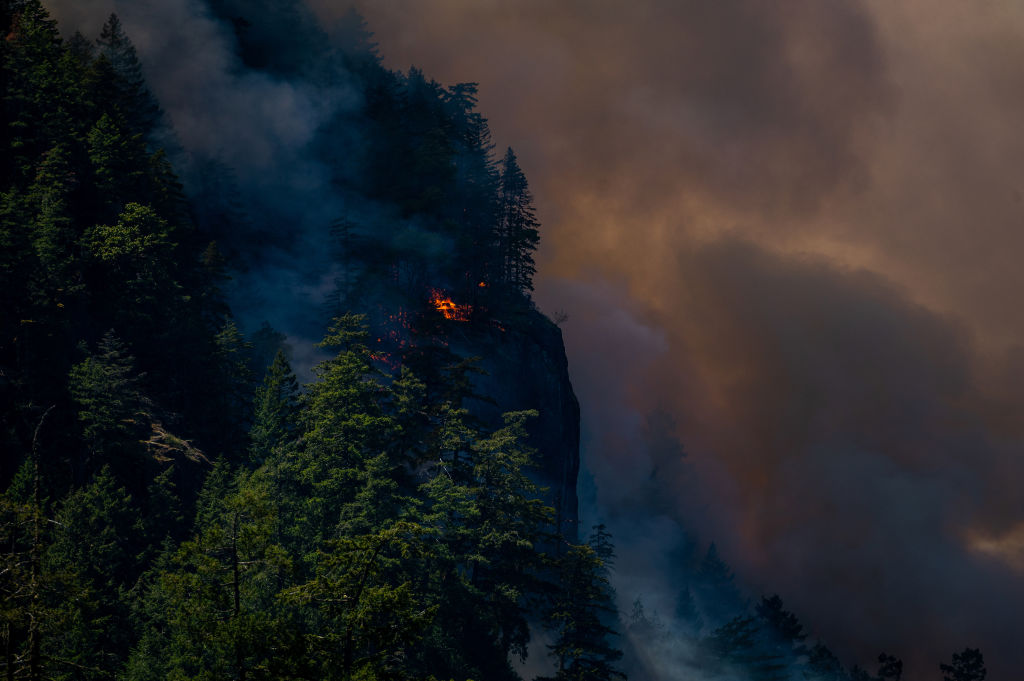 Smoke and flames rise from the Cameron Bluffs wildfire near Port Alberni, British Columbia, Canada, on Tuesday, June 6, 2023. Canada is on track to see its worst-ever wildfire season in recorded history if the rate of land burned continues at the same pace. Photographer: James MacDonald/Bloomberg via Getty Images