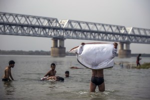 Indianos se refrescam no rio Ganges, em Patna, na Índia, durante onda de calor