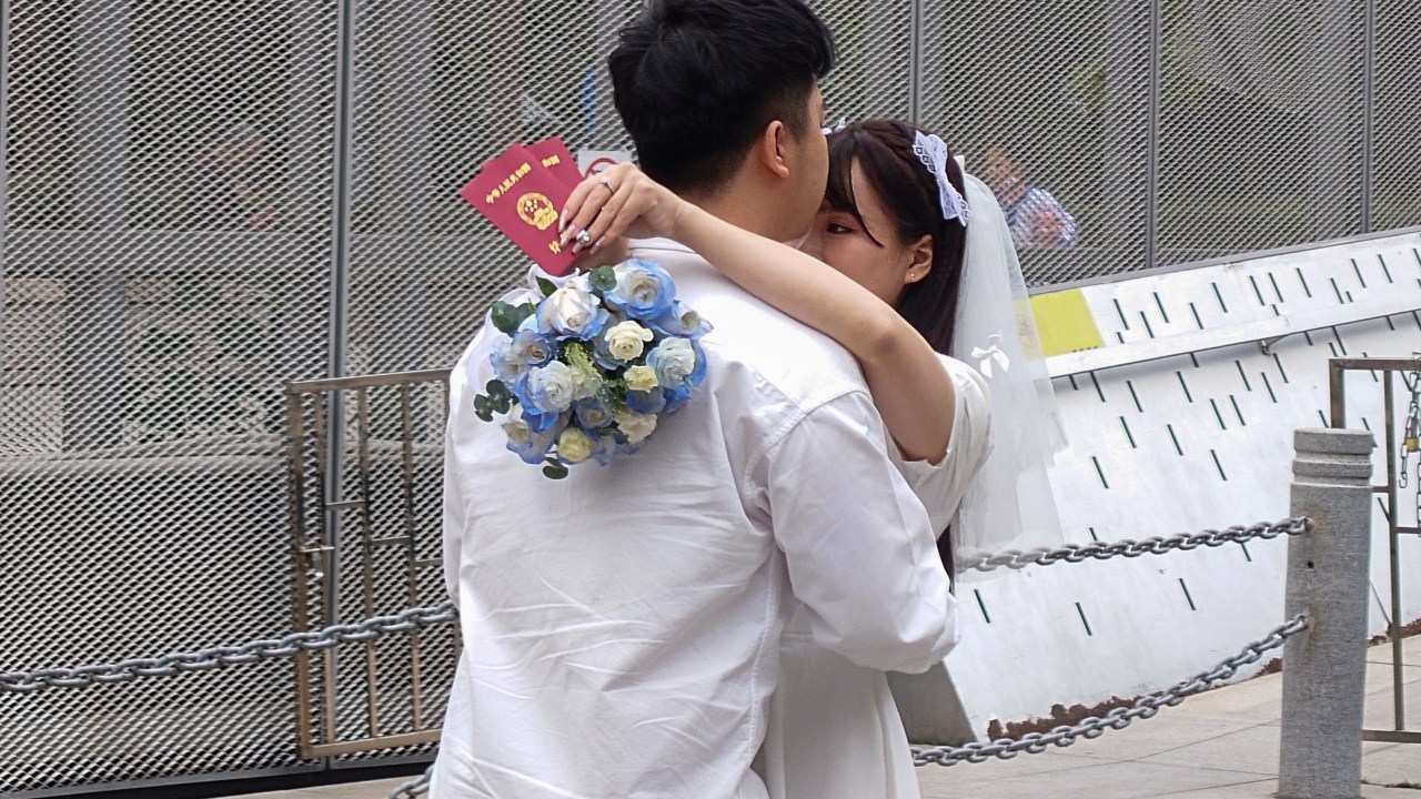 SHENZHEN, CHINA - FEBRUARY 14: A newlywed couple pose with their marriage certificates outside a civil affairs bureau on Valentine's Day on February 14, 2023 in Shenzhen, Guangdong Province of China. (Photo by VCG/VCG via Getty Images)