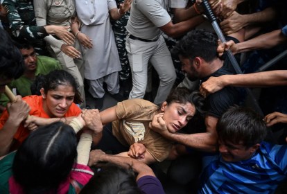 As lutadoras Sangeeta Phogat, à esquerda, e Vinesh Phogat, ao centro, são detidas pela polícia enquanto tentavam marchar para o novo parlamento da Índia durante um protesto contra Brij Bhushan Singh em Nova Delhi -