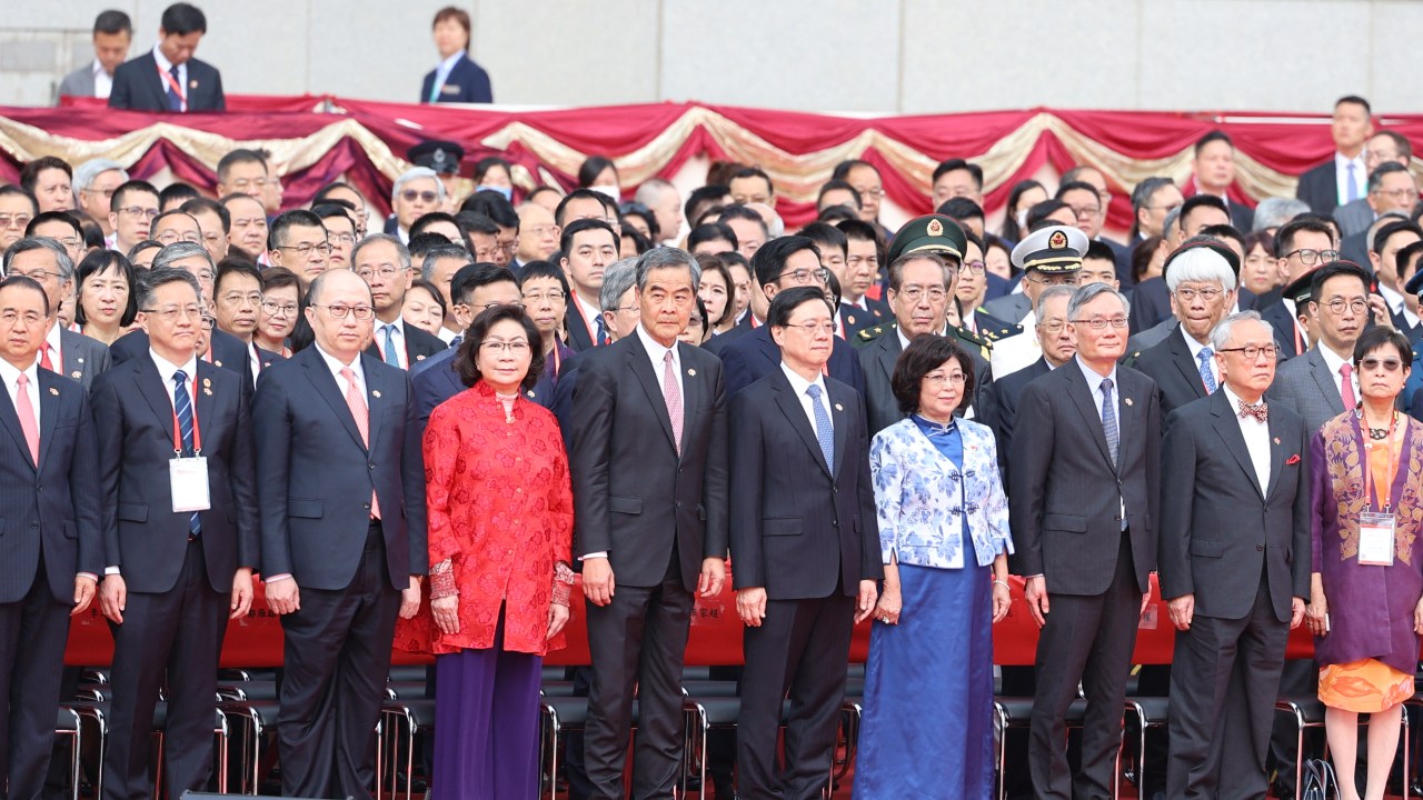 From L-R: Liu Guangyuan, Commissioner of China's Ministry of Foreign Affairs in Hong Kong; Li Jiangzhou, deputy director of the Office for Safeguarding National Security in Hong Kong; Zheng Yanxiong, director of the Liaison Office of the Central People's Government in Hong Kong; Regina Leung, wife of former Hong Kong chief executive CY Leung; former Hong Kong chief executive CY Leung; Hong Kong chief executive John Lee; Janet Lam, wife of Hong Kong chief executive John Lee; Chief Justice Andrew Cheung; former Hong Kong chief executive Donald Tsang; Selina Tsang, wife of former Hong Kong chief executive Donald Tsang attend a flag-raising event at the Golden Bauhinia Square to mark Hong Kong's 26th anniversary of the former British colony's return to Chinese rule, in Hong Kong on July 1, 2023. (Photo by MAY JAMES / AFP)
