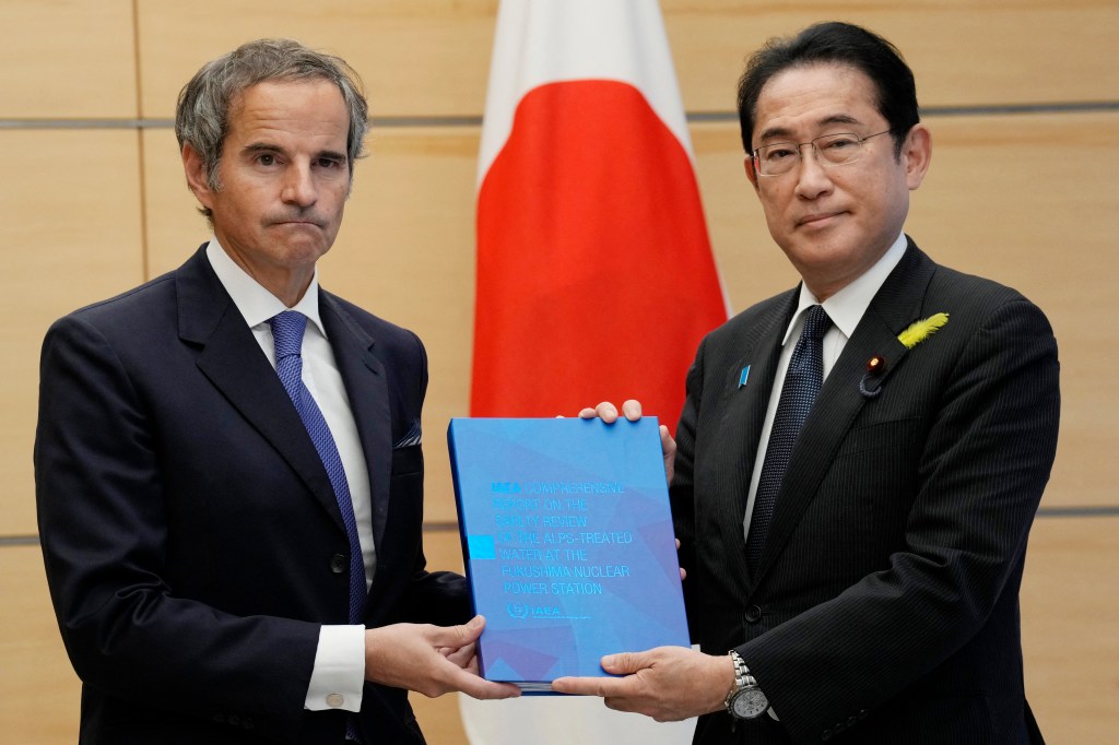 Rafael Grossi (L), Director General of the International Atomic Energy Agency (IAEA), presents IAEA's comprehensive report on Fukushima Treated Water Release to Japan's Prime Minister Fumio Kishida during their meeting at the prime minister's residence in Tokyo on July 4, 2023. (Photo by Eugene Hoshiko / POOL / AFP)