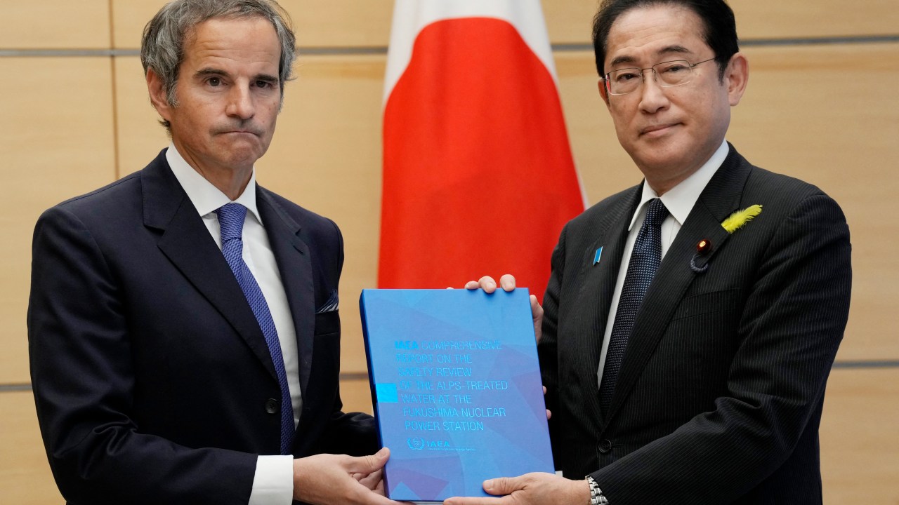 Rafael Grossi (L), Director General of the International Atomic Energy Agency (IAEA), presents IAEA's comprehensive report on Fukushima Treated Water Release to Japan's Prime Minister Fumio Kishida during their meeting at the prime minister's residence in Tokyo on July 4, 2023. (Photo by Eugene Hoshiko / POOL / AFP)