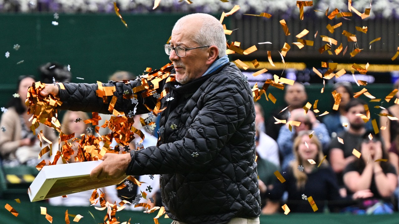 A Just Stop Oil demonstrator throws orange confetti on court 18 as he disrupts the women's singles tennis match between Australia's Daria Saville and Britain's Katie Boulter on the third day of the 2023 Wimbledon Championships at The All England Tennis Club in Wimbledon, southwest London, on July 5, 2023. (Photo by Glyn KIRK / AFP) / RESTRICTED TO EDITORIAL USE
