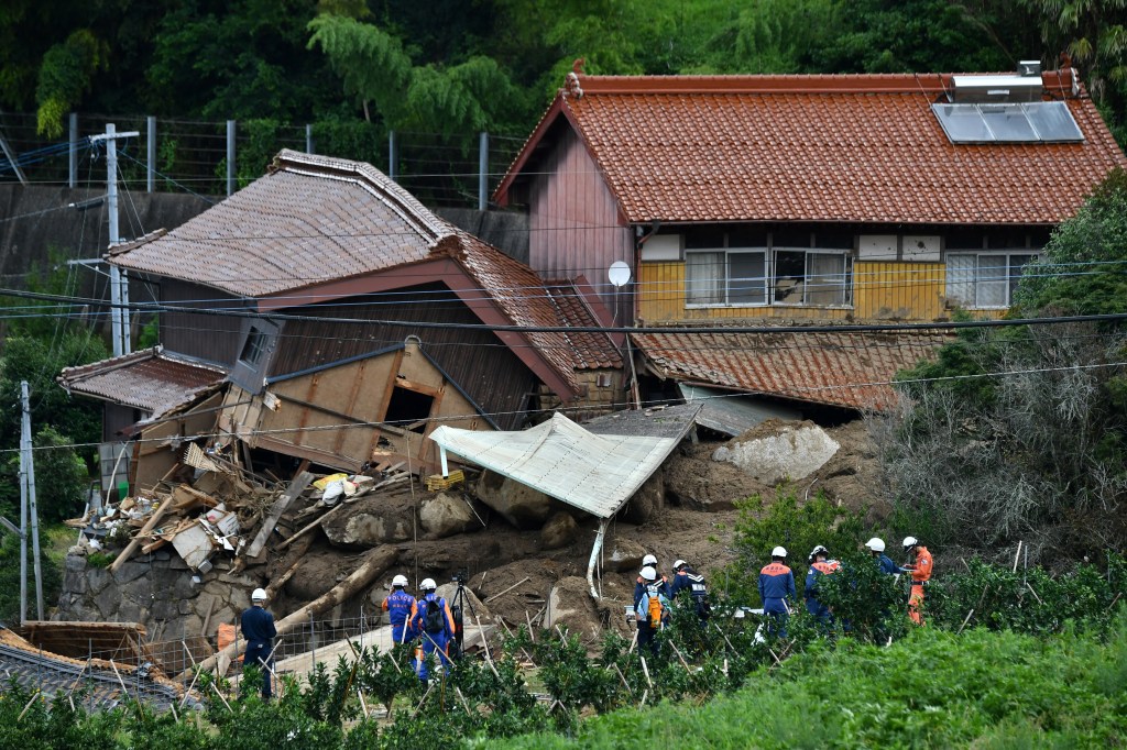Rescue teams gather at the site of a landslide in Karatsu City, Saga prefecture, on July 11, 2023, after heavy rains hit wide areas of Kyushu island. At least two people were killed in torrential rain in southwest Japan on July 10, with fears the toll could rise, as tens of thousands of residents were told to evacuate their homes. (Photo by Kazuhiro NOGI / AFP)