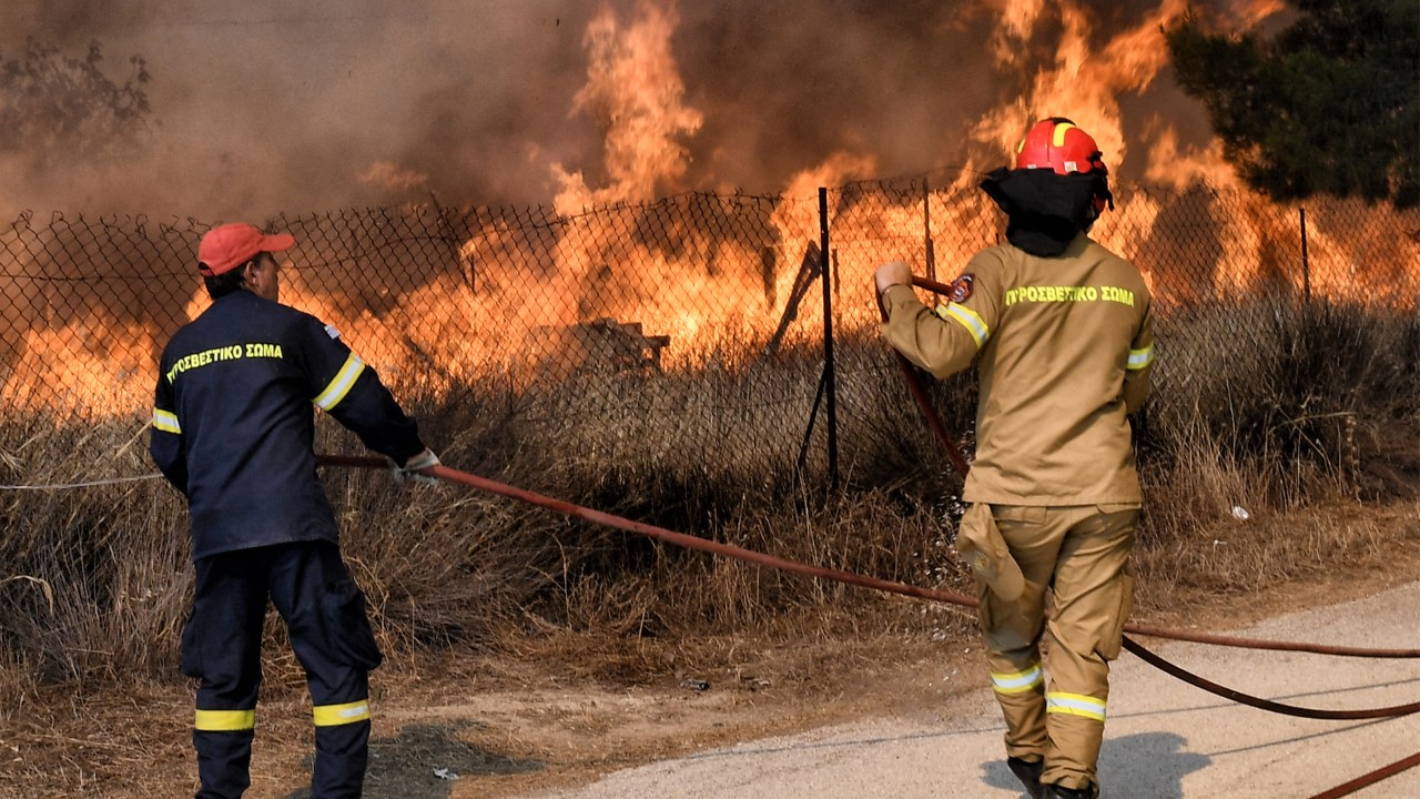 Firemen battle the wildfire in the settlement of Irini, near the resort town of Loutraki, some 80 kilometres east of Athens, on July 17, 2023. Greek police on July 17, 2023 arrested a man suspected of starting an ongoing wildfire near Athens fuelled by a heatwave and strong winds, firefighters said."Police carried out the arrest of a foreigner who allegedly caused the fire" in Kouvaras, around 50 kilometres (30 miles) southeast of Athens, said fire service spokesman Yannis Artopios. (Photo by Valerie GACHE / AFP)
