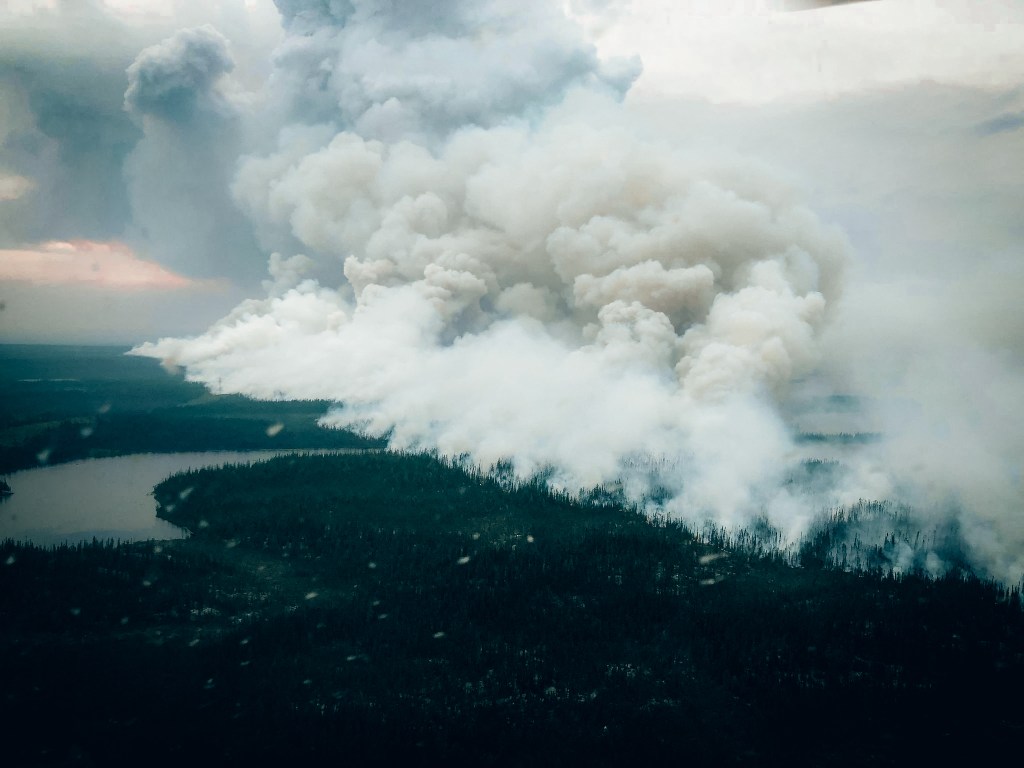 This July 14, 2023, aerial image released by the Societe De Protection Des Forets (SOPFEU) on July 18, 2023, shows wildfire smoke engulfing a forest in the northern zone of Canada's Quebec Province. Nearly 900 wildfires are currently burning across Canada, about 580 of which remain out of control, according to media reports. Two firefighters have been killed as the country battles its worst season of wildfires on record. (Photo by Anthony ROLLAND / Societe De Protection Des Forets / AFP) / RESTRICTED TO EDITORIAL USE - MANDATORY CREDIT "AFP PHOTO / Anthony ROLLAND/SOPFEU" - NO MARKETING NO ADVERTISING CAMPAIGNS - DISTRIBUTED AS A SERVICE TO CLIENTS