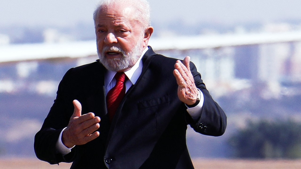 Brazilian President Luiz Inacio Lula da Silva gestures as he arrives to the Brasilia Air Force Base to attend a ceremony commemorating the 150th birthday of Brazilian aviator and inventor Alberto Santos Dumont, considered the patron saint of the Brazilian Air Force, in Brasilia on July 20, 2023. (Photo by Sergio Lima / AFP)