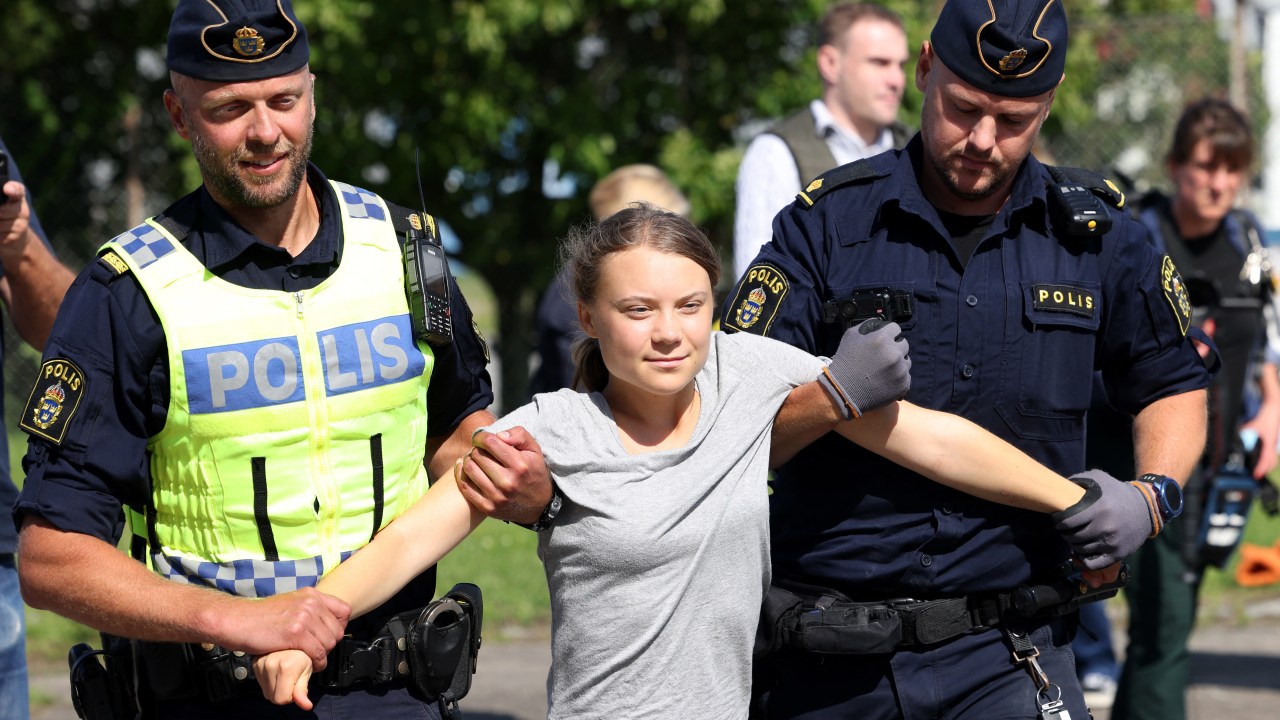 Climate activist Greta Thunberg is carried away by police officers after she took part in a new climate action in Oljehamnen in Malmo, Sweden on July 24, 2023, shortly after the city's district court convicted and sentenced her to a fine for disobeying police at a rally last month during a climate action in the Norra hamnen neighbourhood of Malmo. Thunberg was fined on Monday for disobeying police at a rally last month, but said she acted out of necessity due to the climate crisis. (Photo by Andreas HILLERGREN / TT News Agency / AFP) / Sweden OUT