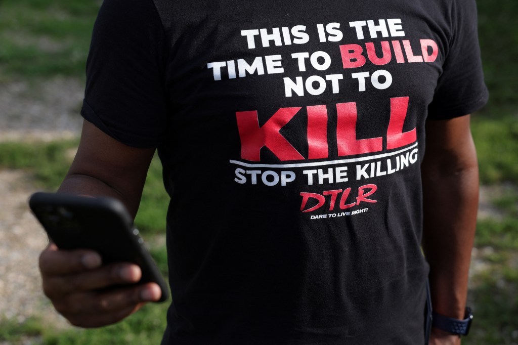 BALTIMORE, MARYLAND - JULY 03: A man wears a T-shirt calling for stopping the killing prior to a We Our Us Movement "community walk" to show support in the Brooklyn Homes neighborhood on July 3, 2023 in Baltimore, Maryland. Two people were killed and dozens injured, many of them minors, during a mass shooting at a block party in the South Baltimore neighborhood. Alex Wong/Getty Images/AFP (Photo by ALEX WONG / GETTY IMAGES NORTH AMERICA / Getty Images via AFP)