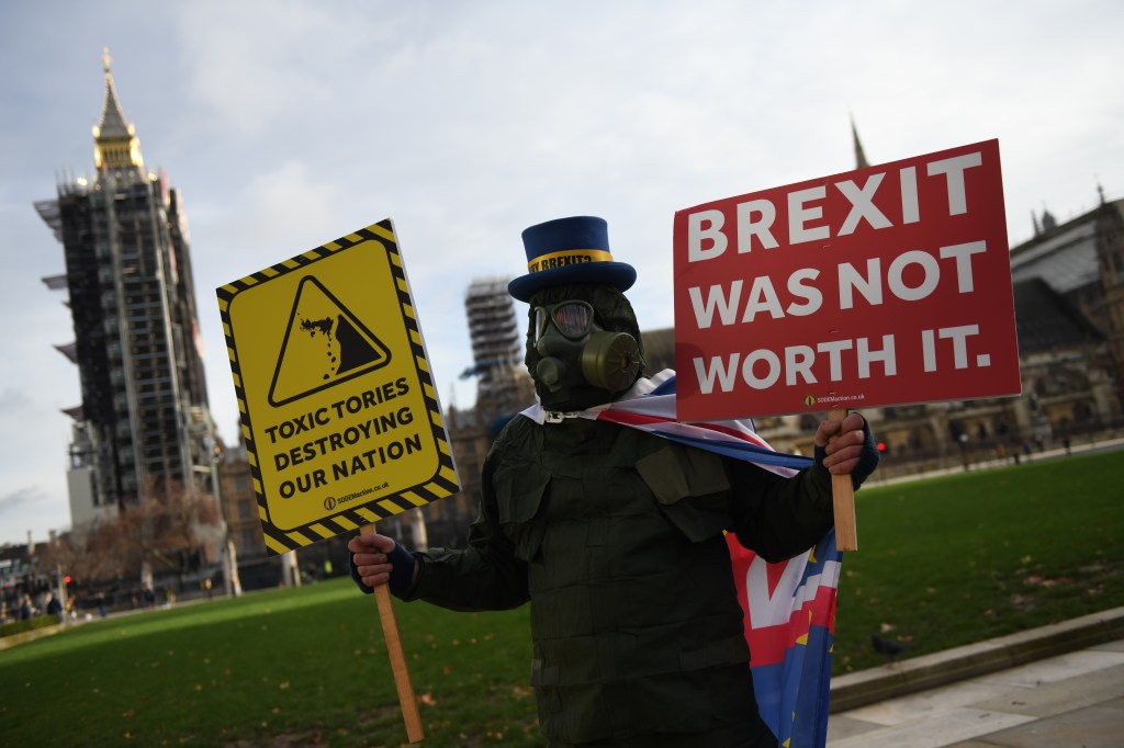 LONDON, ENGLAND - DECEMBER 30: Anti Brexit campaigner, Steve Bray holds placards while wearing a gas mask outside parliament on December 30, 2020 in London, England. The United Kingdom and the European Union agreed a Trade and Cooperation Agreement, an Agreement on Nuclear Cooperation and an Agreement on Security Procedures for Exchanging and Protecting Classified Information on Christmas Eve 2020. These Agreements change the basis of the UK's relationship with the EU from EU law to free trade and friendly cooperation. In a referendum of 23 June 2016 the British people voted to take back control of their laws, borders, money, trade and fisheries, commonly referred to as Brexit. (Photo by Chris J Ratcliffe/Getty Images)