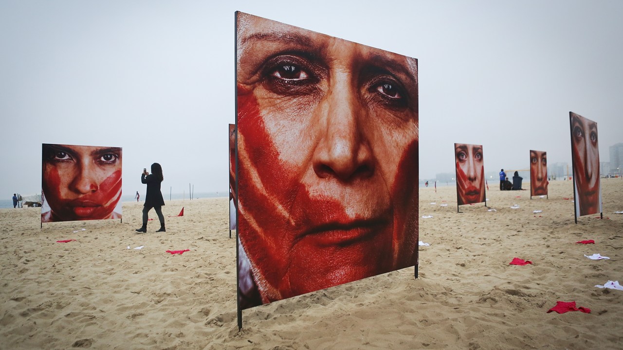 Fotografias de Marcio Freitas de modelos retratando mulheres que são abusadas são exibidas na praia de Copacabana em 6 de junho de 2016