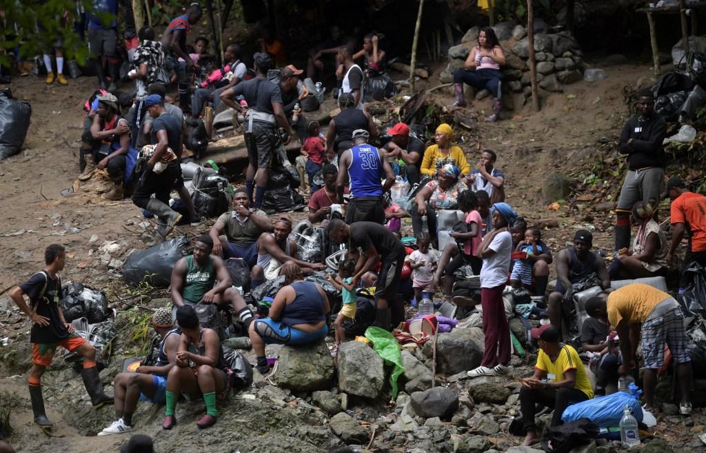 (FILES) Haitian migrants rest as they cross the jungle of the Darien Gap, near Acandi, Choco department, Colombia, heading to Panama, on September 26, 2021, on their way trying to reach the US. Halfway into 2023, nearly a quarter million migrants have crossed the Darien Gap, the dense jungle separating Panama and Colombia, already breaking last year's record, Panama's government said on July 31, 2023. The Darien Gap, 165 miles (265 kilometres) long, has become a corridor from South America for migrants heading to the United States via Central America, despite its dangers. (Photo by Raul ARBOLEDA / AFP)