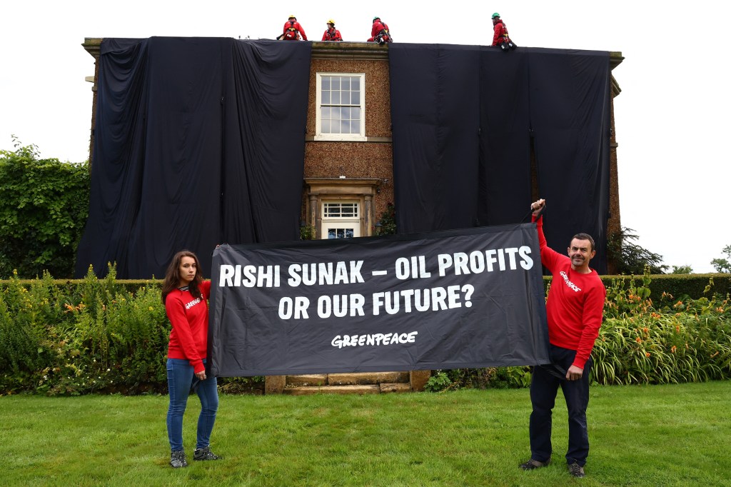 A handout picture taken and released by environmental action group Greenpeace on August 3, 2023 shows Greenpeace activists on the roof of Britain's Prime Minister Rishi Sunak's manor house in Kirby Sigston, northern England, to protest at his backing for new oil and gas licences in the North Sea. (Photo by Luca MARINO / Greenpeace United Kingdom / AFP) / RESTRICTED TO EDITORIAL USE - MANDATORY CREDIT "AFP PHOTO / GREENPEACE / LUCA MARINO" - NO MARKETING NO ADVERTISING CAMPAIGNS - DISTRIBUTED AS A SERVICE TO CLIENTS --- NO ARCHIVE ---