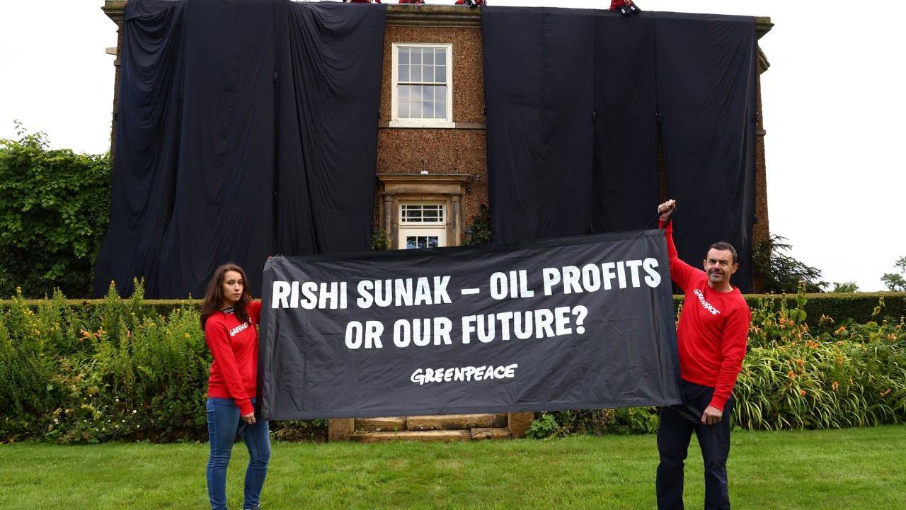A handout picture taken and released by environmental action group Greenpeace on August 3, 2023 shows Greenpeace activists on the roof of Britain's Prime Minister Rishi Sunak's manor house in Kirby Sigston, northern England, to protest at his backing for new oil and gas licences in the North Sea. (Photo by Luca MARINO / Greenpeace United Kingdom / AFP) / RESTRICTED TO EDITORIAL USE - MANDATORY CREDIT "AFP PHOTO / GREENPEACE / LUCA MARINO" - NO MARKETING NO ADVERTISING CAMPAIGNS - DISTRIBUTED AS A SERVICE TO CLIENTS --- NO ARCHIVE ---