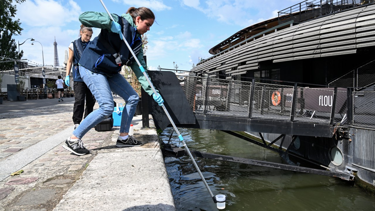 Uma funcionária da empresa Fluidion coleta uma amostra de água do Sena para analisar sua composição antes de evento pré-Olímpico de natação, em Paris. 04/08/2023