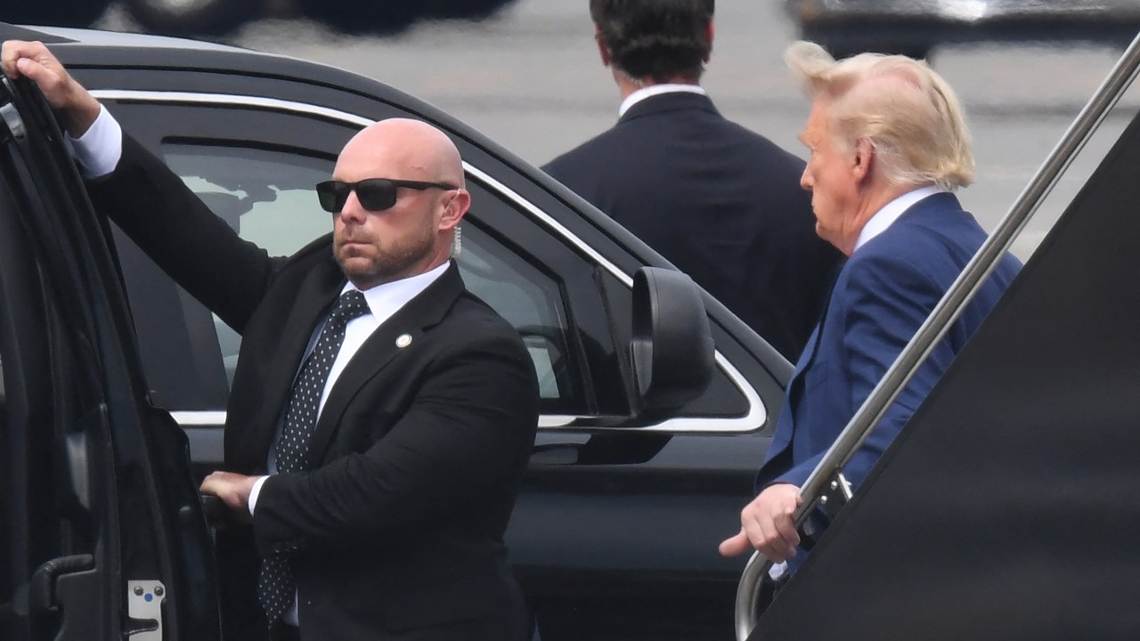 Former US President and 2024 hopeful Donald Trump (R) disembarks his plane "Trump Force One" on arrival at Ronald Reagan Washington National Airport in Arlington, Virginia, on August 3, 2023. Trump is expected to appear in court on Thursday to answer charges of conspiring to overturn the 2020 election, a case that will cast a dark and volatile cloud over the 2024 White House race for which he remains the presumptive Republican nominee. (Photo by OLIVIER DOULIERY / AFP)