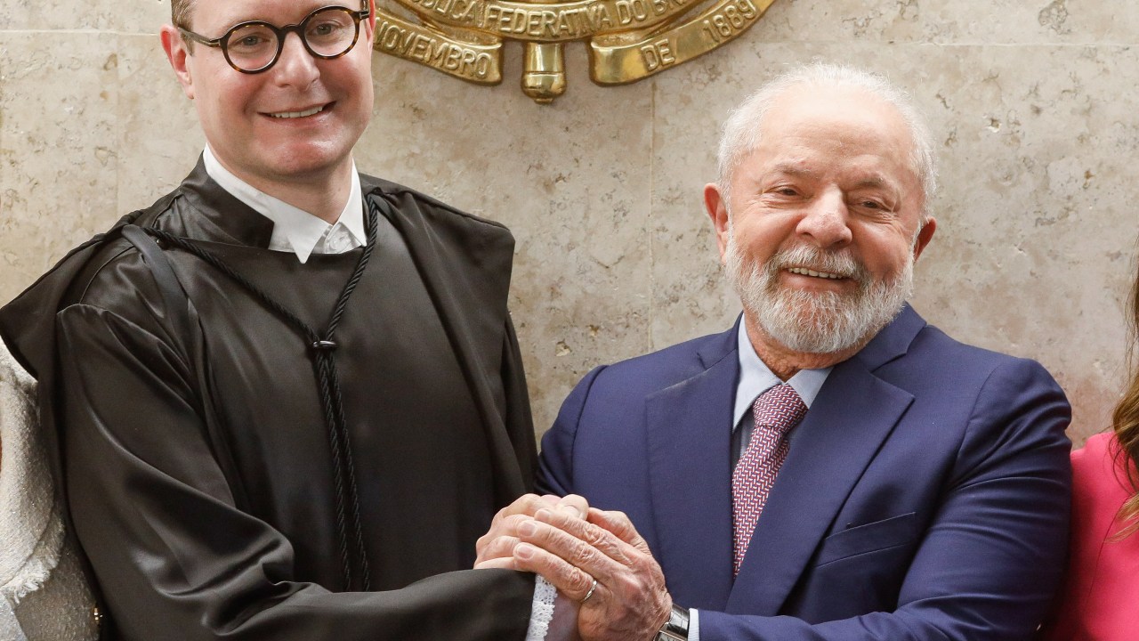 Brazilian President Luiz Inacio Lula da Silva (R() shakes hands with the new Minister of the Federal Supreme Court, Cristiano Zanin, during the inauguration ceremony in Brasília, on August 3, 2023. Zanin, who had been President Lula da Silva's defense attorney in the 'Car Wash' operation, was appointed by to fill a vacancy on the Supreme Court in place of Ricardo Lewandowski, who left his post last April. (Photo by Sergio Lima / AFP)