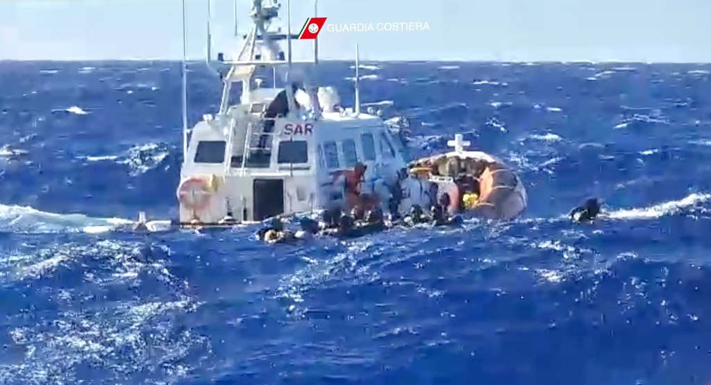 This handout photograph taken on August 5, 2023 by Italian Coastguard (Guardia Costeria) and released on August 6, 2023, shows a rescue operation that took place south of Lampedusa, consisting in rescuing 57 migrants, also recovering the lifeless bodies of a woman and a minor on board. At least 30 migrants are missing following two shipwrecks off the Italian island of Lampedusa, according to survivor testimony, as rescuers on August 26, 2023 winched to safety 34 others stranded on the rocks by rough seas. (Photo by Italian Coastguard / GUARDIA COSTIERA / AFP) / -----EDITORS NOTE --- RESTRICTED TO EDITORIAL USE - MANDATORY CREDIT "AFP PHOTO /HANDOUT/GUARDIA COSTERIA " - NO MARKETING - NO ADVERTISING CAMPAIGNS - DISTRIBUTED AS A SERVICE TO CLIENTS - NO ARCHIVES