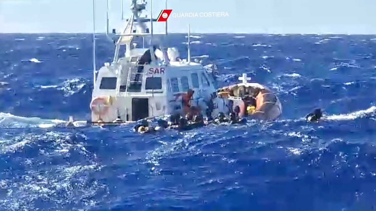 This handout photograph taken on August 5, 2023 by Italian Coastguard (Guardia Costeria) and released on August 6, 2023, shows a rescue operation that took place south of Lampedusa, consisting in rescuing 57 migrants, also recovering the lifeless bodies of a woman and a minor on board. At least 30 migrants are missing following two shipwrecks off the Italian island of Lampedusa, according to survivor testimony, as rescuers on August 26, 2023 winched to safety 34 others stranded on the rocks by rough seas. (Photo by Italian Coastguard / GUARDIA COSTIERA / AFP) / -----EDITORS NOTE --- RESTRICTED TO EDITORIAL USE - MANDATORY CREDIT "AFP PHOTO /HANDOUT/GUARDIA COSTERIA " - NO MARKETING - NO ADVERTISING CAMPAIGNS - DISTRIBUTED AS A SERVICE TO CLIENTS - NO ARCHIVES