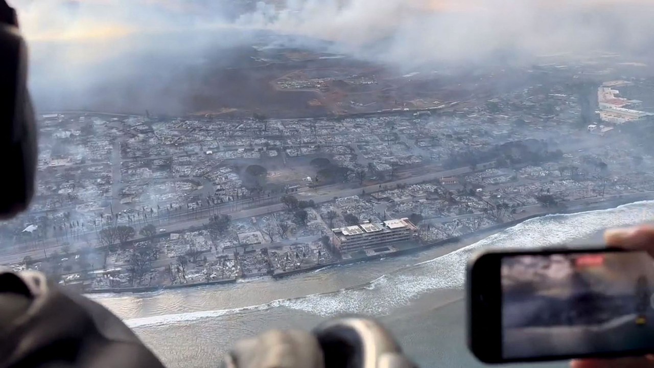 This handout video grab courtesy of Richard Olsten taken on August 9, 2023 shows smoke billowing from destroyed buildings as wildfires burn across Maui, Hawaii. At least six people have been killed in a wildfire that has razed a Hawaiian town, officials said Wednesday, as desperate residents jumped into the ocean in a bid to escape the fast-moving flames. (Photo by Richard Olsten / AFP) / RESTRICTED TO EDITORIAL USE - MANDATORY CREDIT "AFP PHOTO / Richard Olsten" - NO MARKETING NO ADVERTISING CAMPAIGNS - DISTRIBUTED AS A SERVICE TO CLIENTS