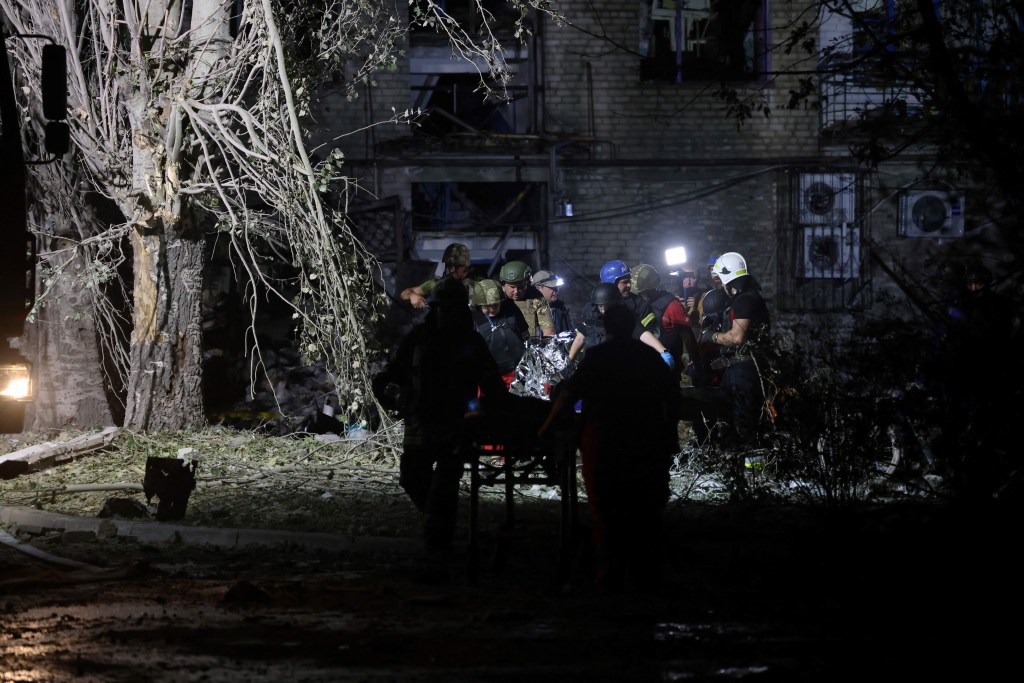 Rescuers carry a wounded person from a damaged residential building following Russian missiles strikes in Pokrovsk, Donetsk region, amid Russian invasion of Ukraine. (Photo by Anatolii STEPANOV / AFP)